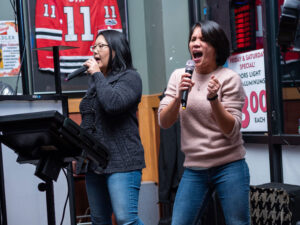 Two women singing karaoke at Brasky's at ACE's Sip and Sing